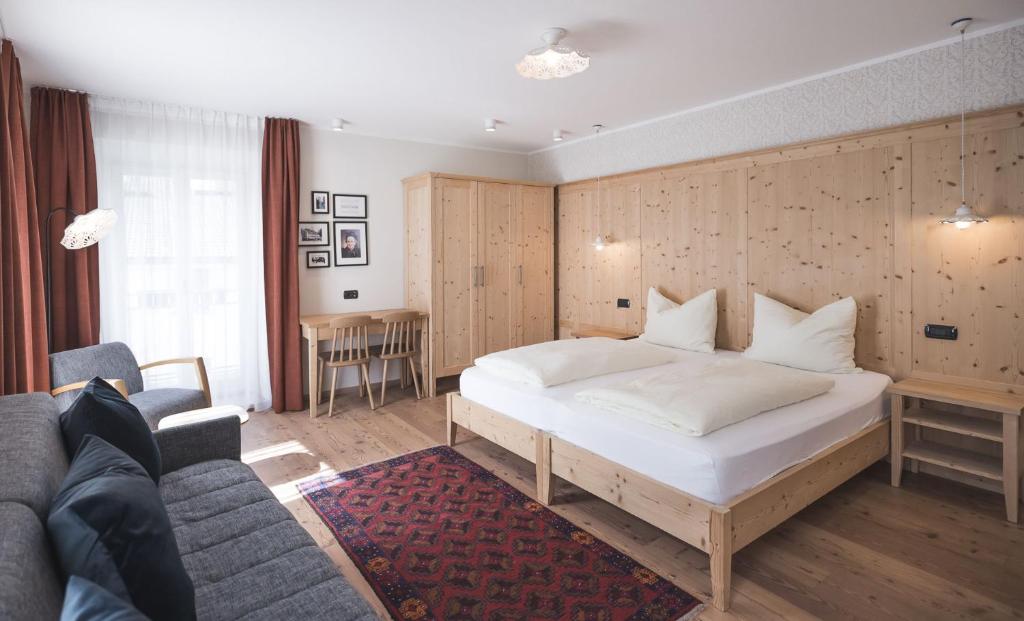 维拉巴萨艾玛西丝德来克酒店的卧室配有一张白色的大床和一张沙发。