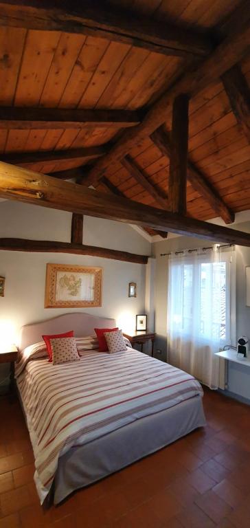 博洛尼亚Altana Sul Tetto的一间卧室设有一张带木制天花板的大床