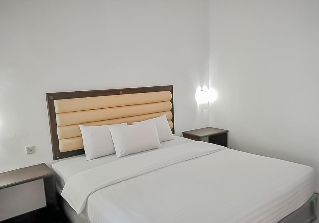 庞岸达兰RedDoorz Syariah near Sunrise Park Pangandaran的一间卧室配有一张带2个床头柜的大型白色床