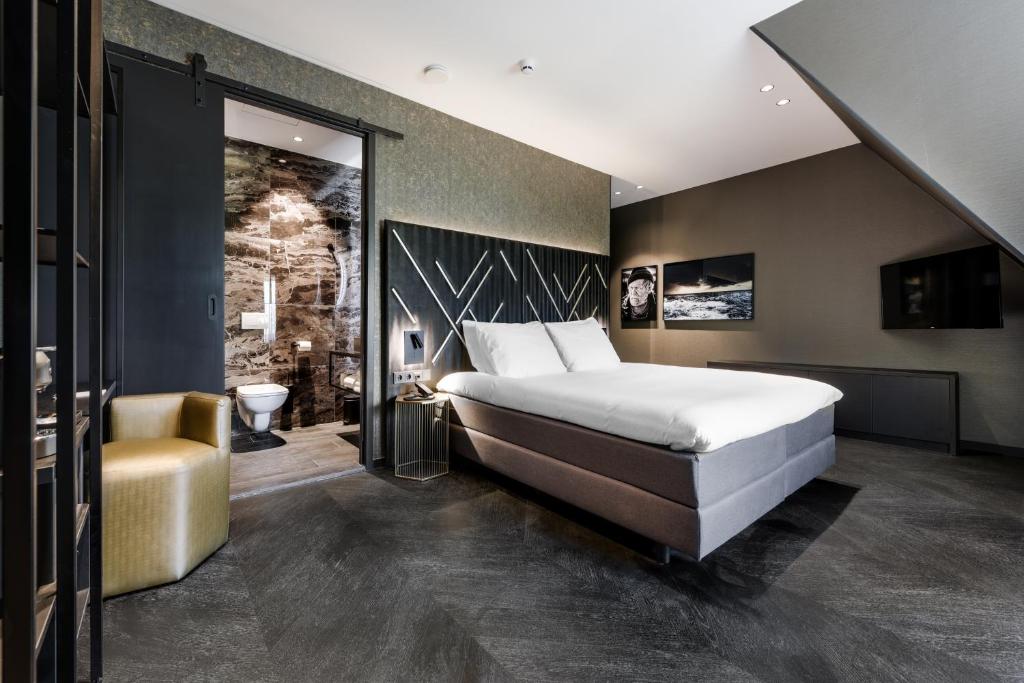 鹿特丹Le Petit Marin Boutique Hotel的一间带大床的卧室和一间浴室