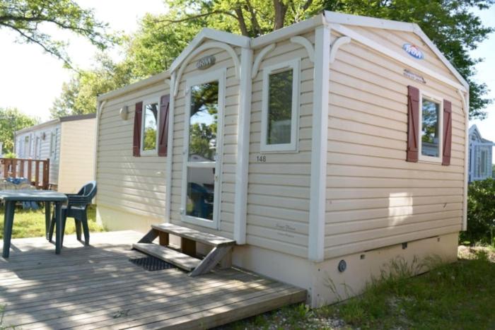 图卢兹CAMPING LE RUPE的白色的小房子,配有桌子和野餐桌