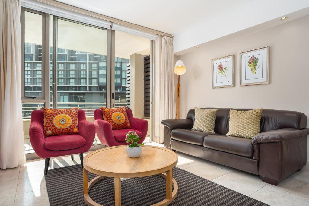 开普敦Canal Quays Apartments的客厅配有沙发、椅子和桌子