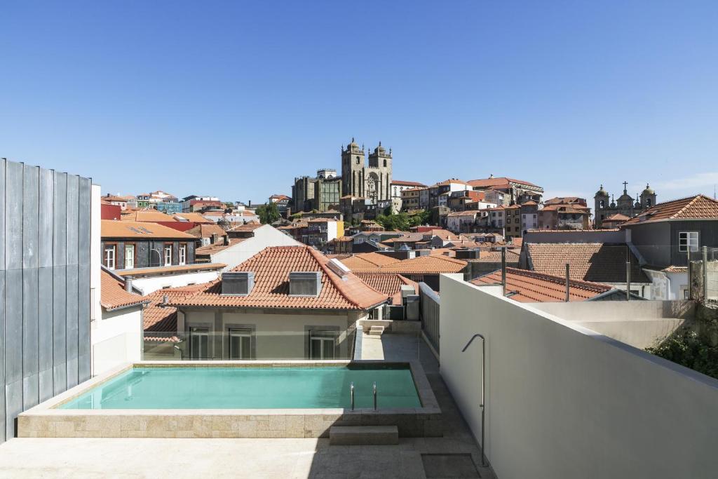 波尔图Casa da Companhia Hotel, Vignette Collection的从带游泳池的建筑屋顶上欣赏美景