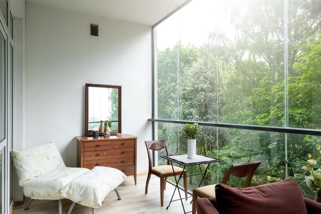 维尔纽斯Spacious apartment with cozy balcony by URBAN RENT的客厅设有大窗户、桌子和椅子