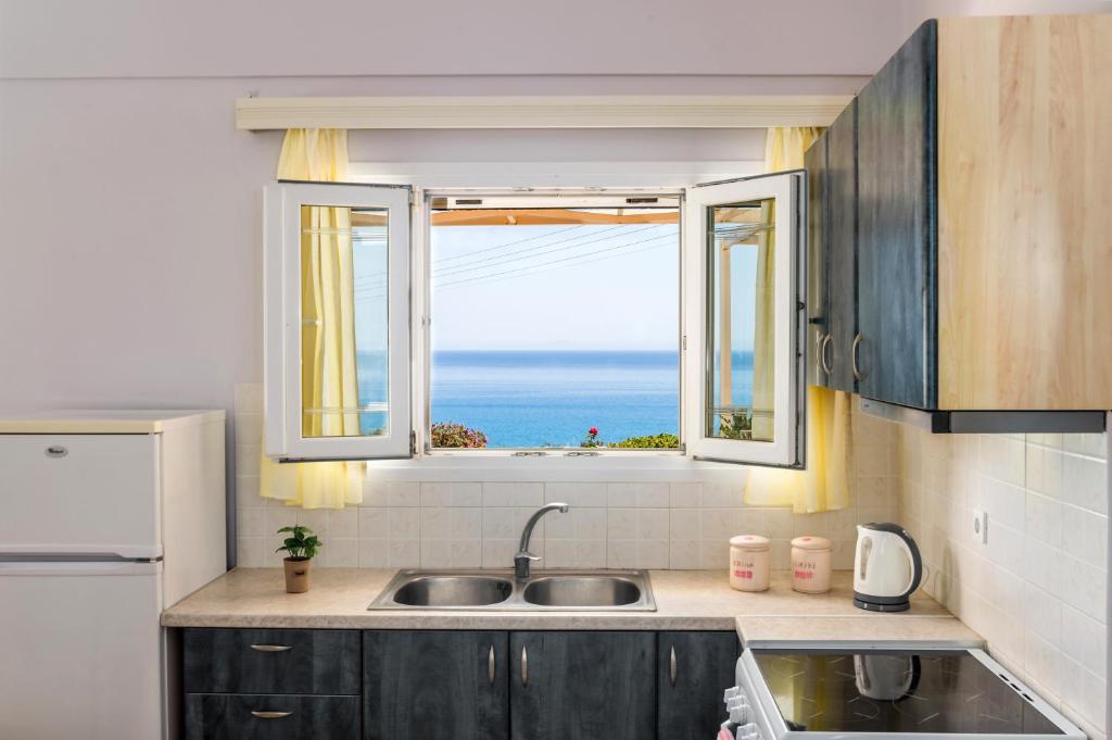 佩萨达Asta La Vista Maisonettes的带水槽的厨房和海景窗户