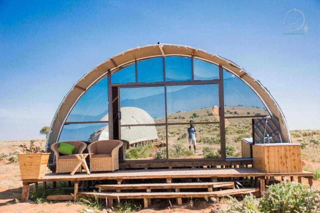 安博塞利Amanya Camp 1-Bed Tent Elephant Suite in Amboseli的圆顶房子,有一个人站在窗户上