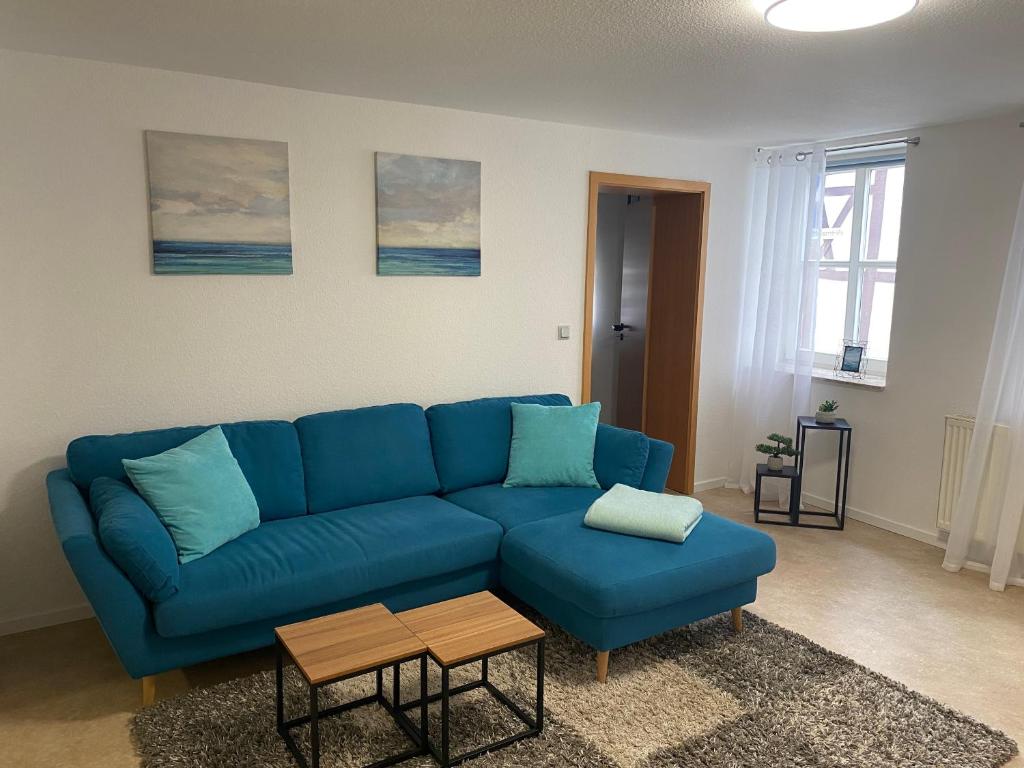 诺特海姆Apartment Häuserstraße 15的客厅配有蓝色的沙发和桌子