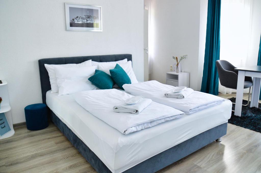 亚伊采马里沃宾馆的一间卧室配有带白色床单和蓝色枕头的床。