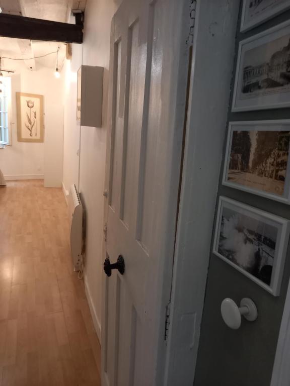 图尔Charmant studio dans le Vieux Tours的走廊上设有白色门,墙上挂有图片