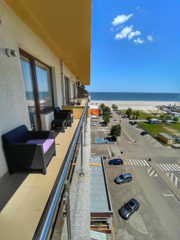 马马亚Sunset Sea View Apartament的阳台配有沙发,享有海滩美景