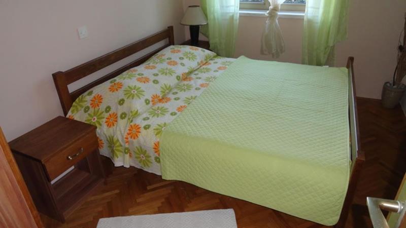 蒙达尼耶Apartment in Palit with Terrace, Air conditioning, Wi-Fi (4603-1)的一间卧室配有一张带绿色棉被的床