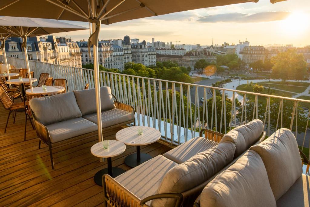 巴黎The People - Paris Nation的阳台设有沙发和桌子,享有城市美景。