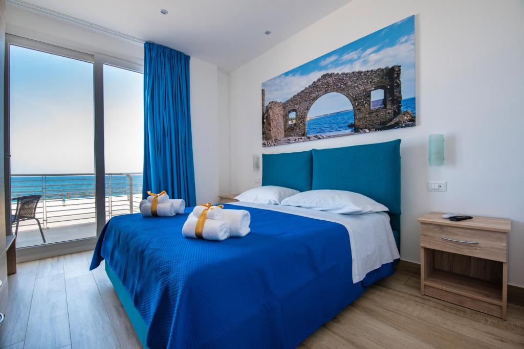 阿沃拉White Apartments & Spa的一间享有海景的卧室,配有一张蓝色的床