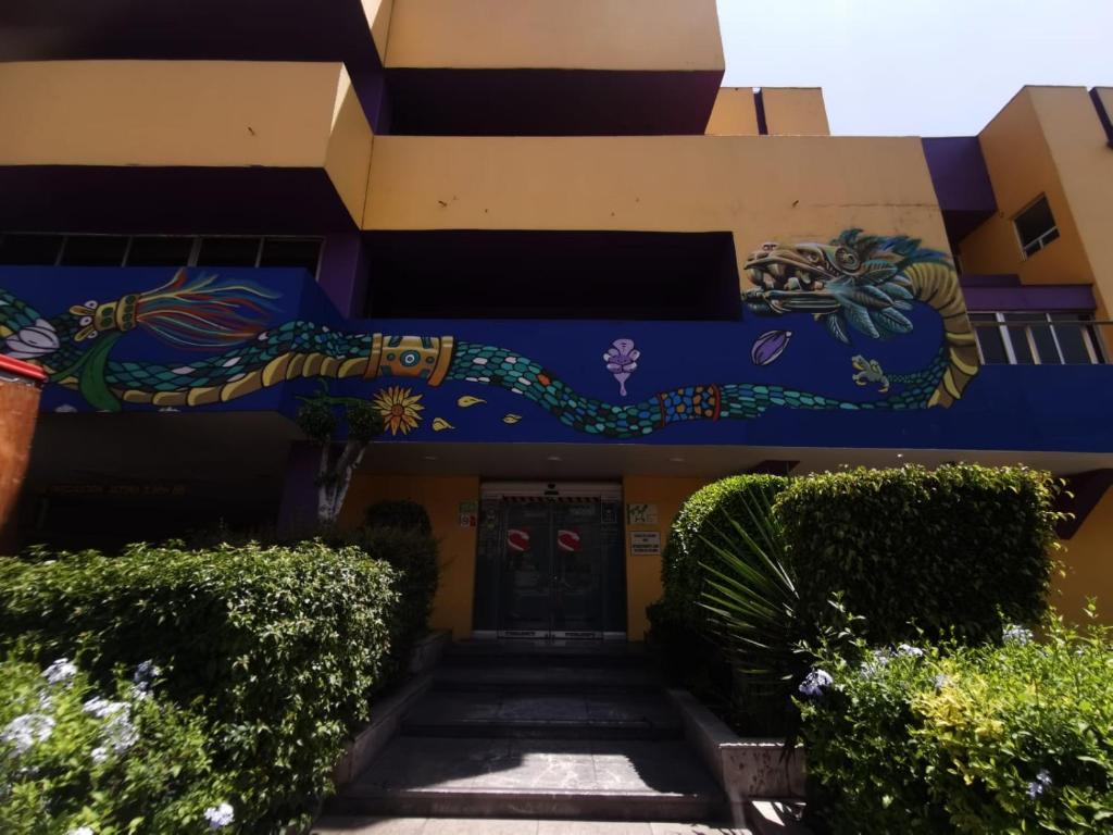 墨西哥城Hotel Coacalco的一面有画的建筑物