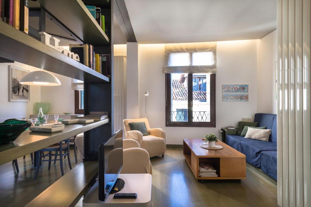 威尼斯MANSARDINA - 1 min from Accademia - duplex stylish and cosy的客厅配有沙发和带电视的桌子
