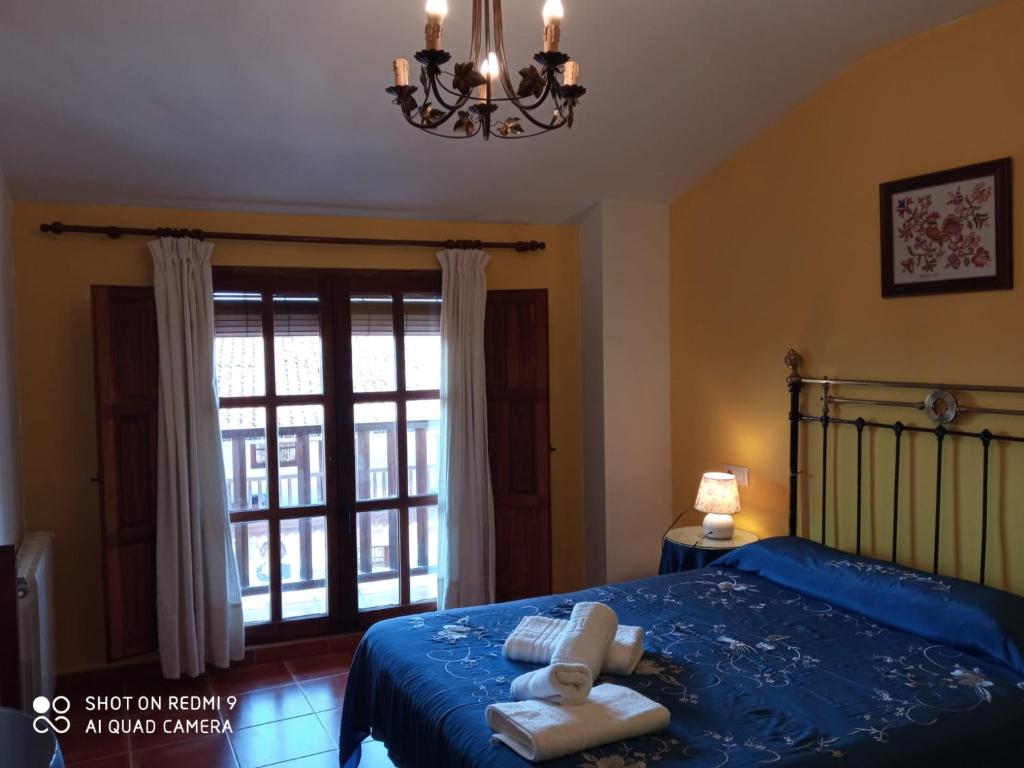莫加拉斯El Humilladero的一间卧室配有蓝色的床和毛巾