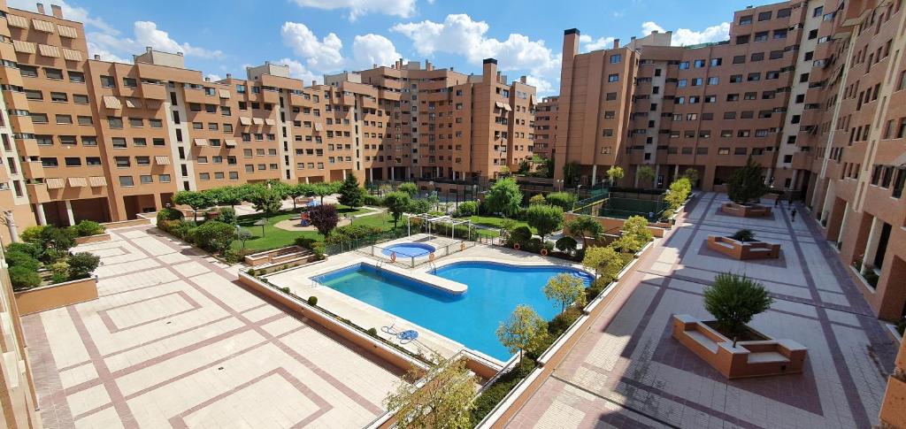 马德里Residencial Caliza的享有带游泳池的大型公寓大楼的顶部景致