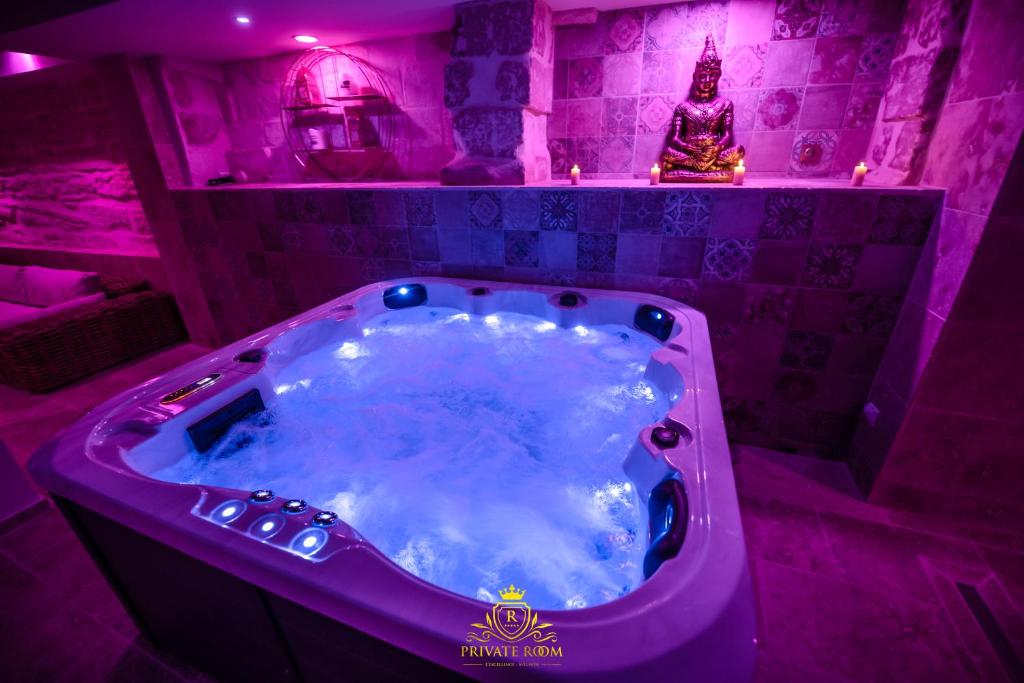 阿维尼翁L'EXCELLENCE AVIGNON - Suite LUXE SAUNA, HAMMAM & JACCUZZI的紫色浴室设有按摩浴缸