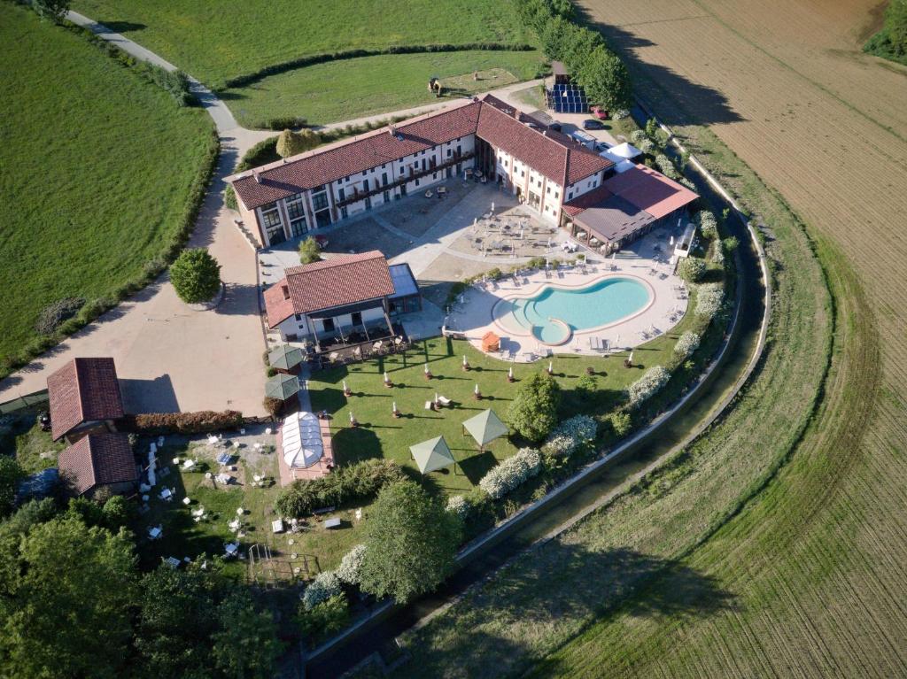 菲亚诺Relais Bella Rosina Pool & Spa的享有带游泳池的大房子的空中景致