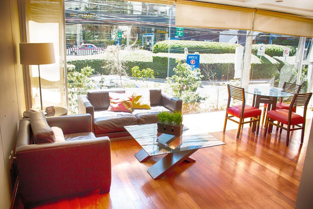 墨西哥城Suites Aura For Living的客厅配有沙发和桌椅