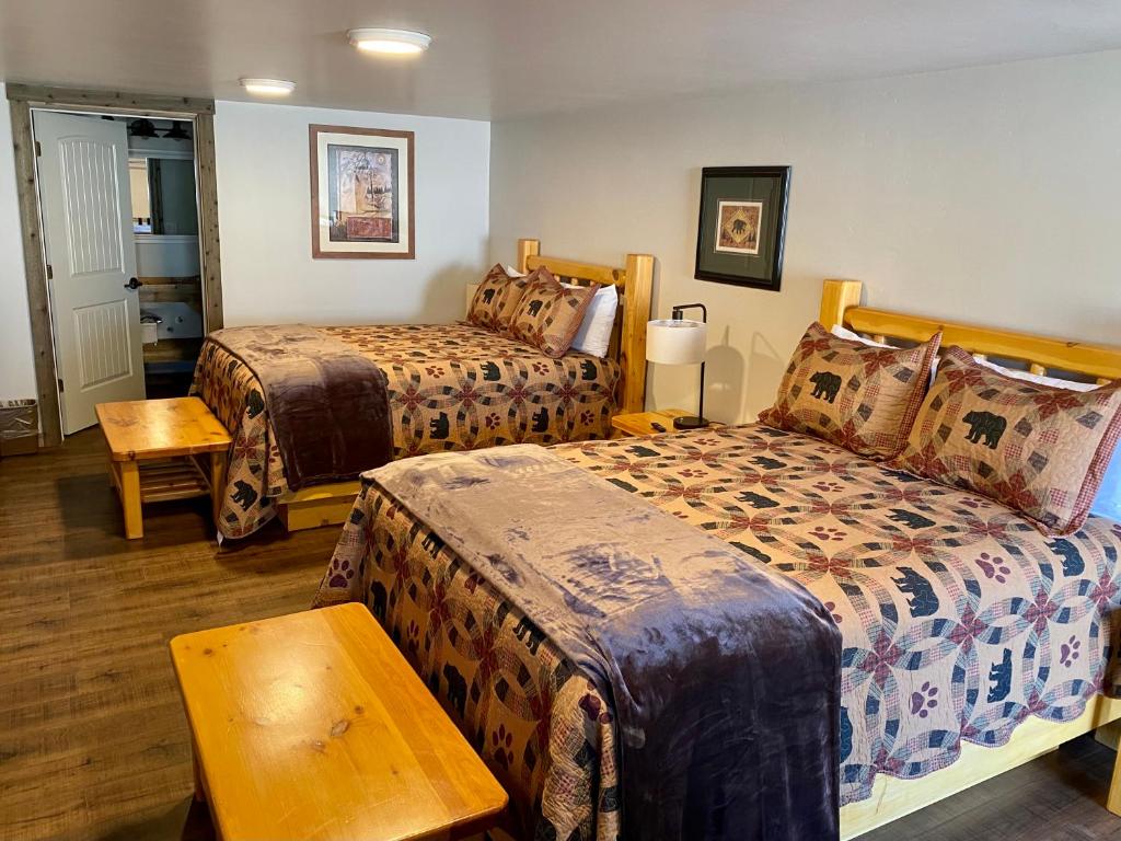 艾兰帕克Island Park Lodge的酒店客房设有两张床和一张桌子。