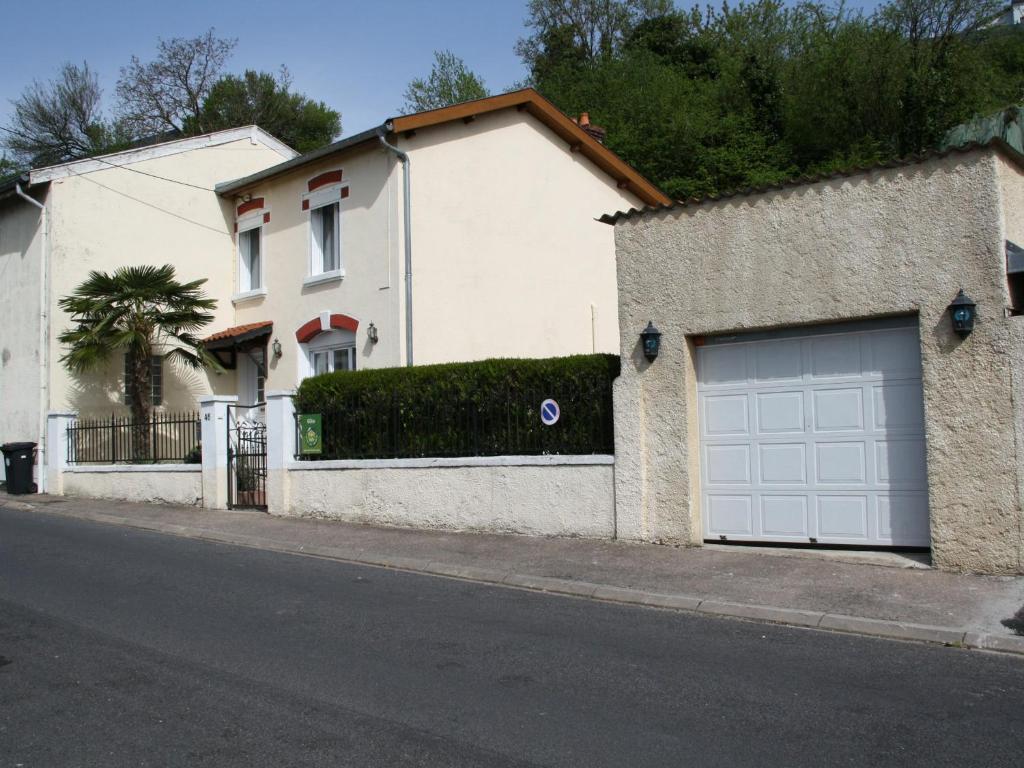 Belleville-sur-MeuseGîte Belleville-sur-Meuse, 4 pièces, 4 personnes - FR-1-585-42的白色的房子,在街上有两扇车库门