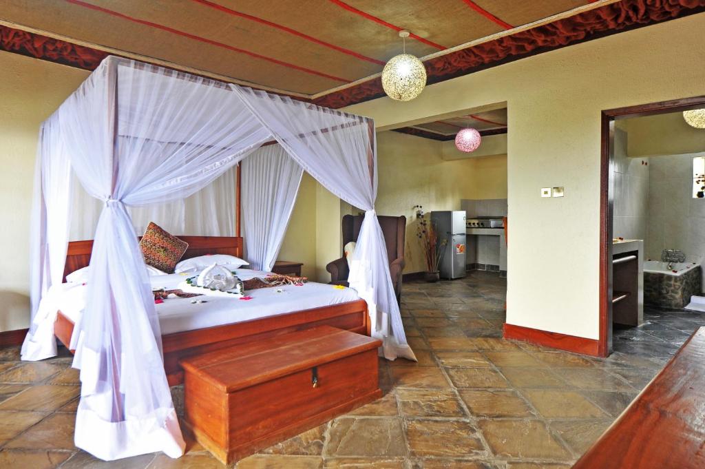 奈瓦沙Mwanzo Lodge的一间卧室配有一张带天蓬的床