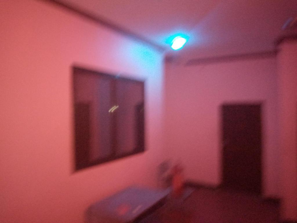 达累斯萨拉姆Kicec bar and guest house airport的一间有粉红色墙壁的房间,上面有灯