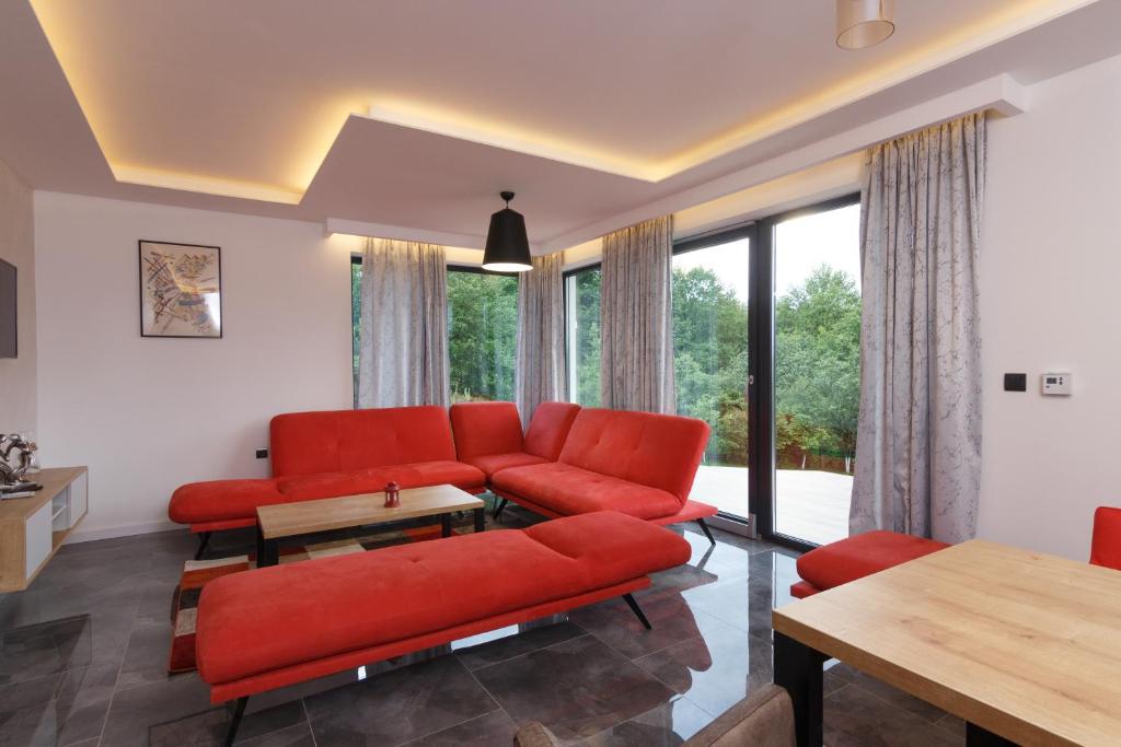 维索科Deluxe Feliciano Apartments的客厅设有红色家具和大窗户