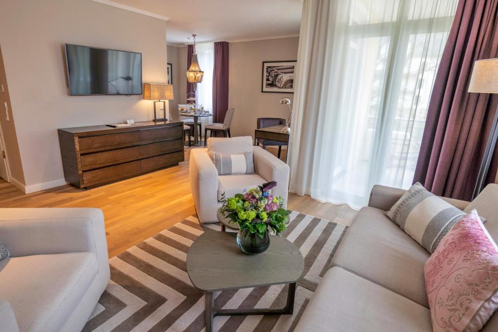 兰河畔马尔堡维拉维塔罗森公园酒店的客厅配有沙发、椅子和电视
