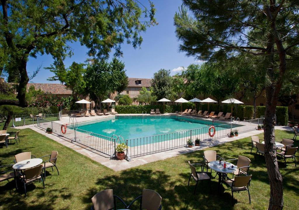 阿尔玛格鲁帕拉朵阿尔马格罗酒店的一个带桌椅和遮阳伞的游泳池