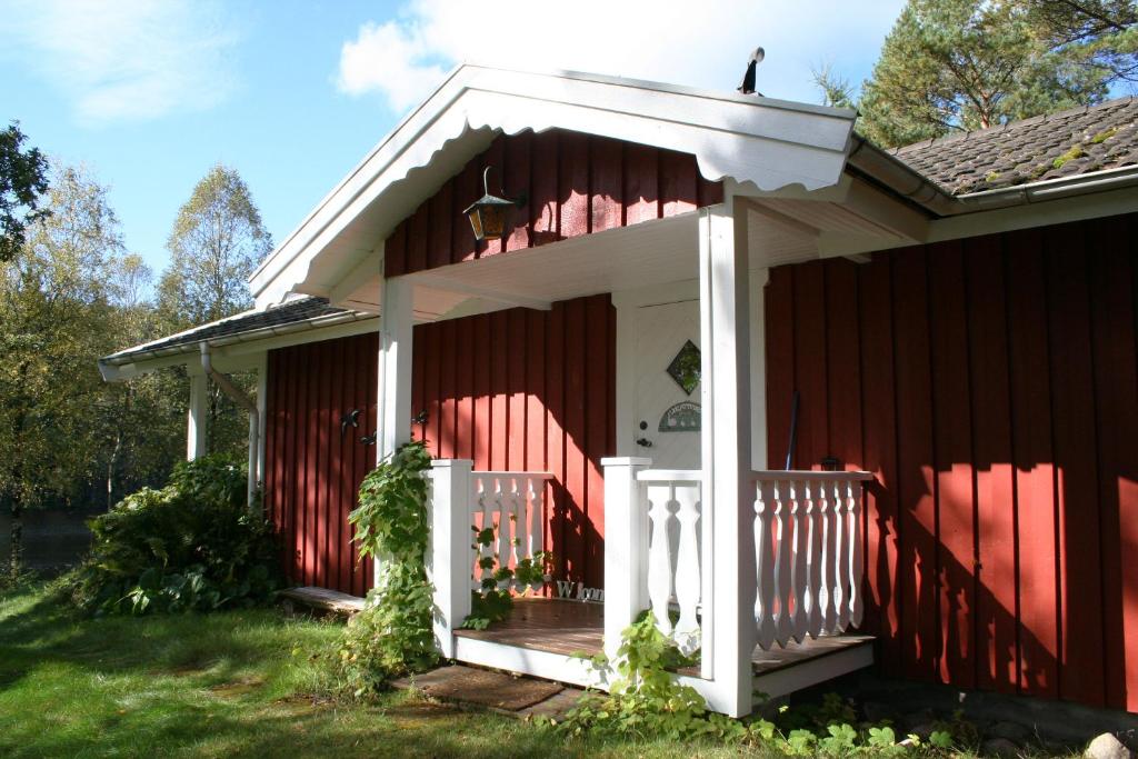 哥德堡Björsjödal Lake House's的一间红色的房子,有白色的门和门廊