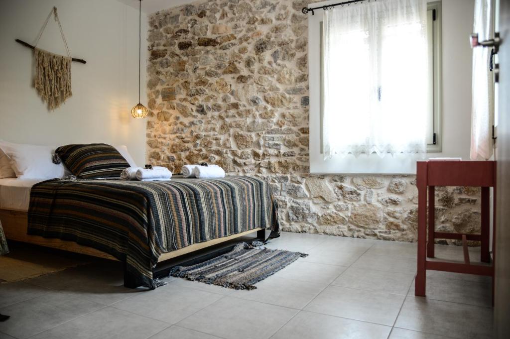 斯巴达Deus Apartments_ Athens Airport的一间卧室设有一张床和石墙