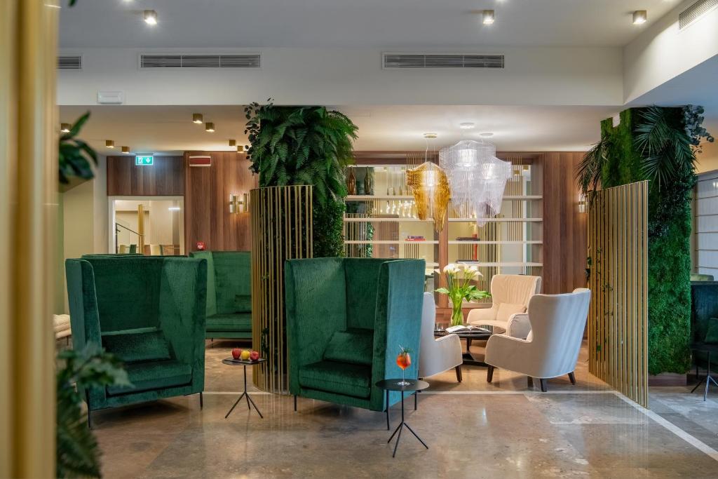米兰托克齐酒店的大堂设有绿色椅子和桌子