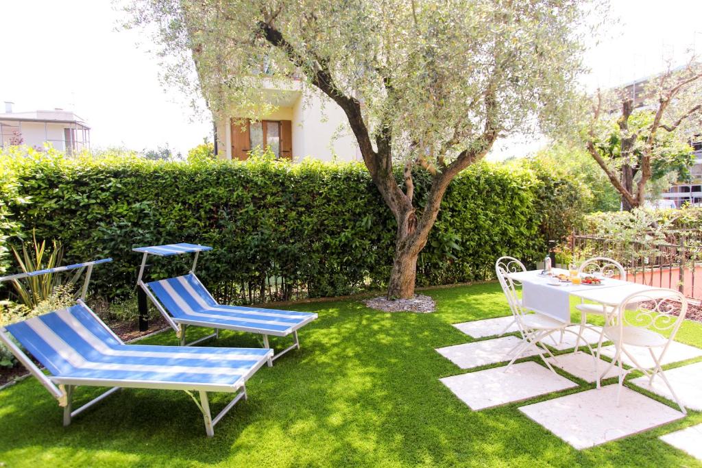 代森扎诺-德尔加达Maison Olive的一个带两把椅子和一张桌子的院子和一棵树
