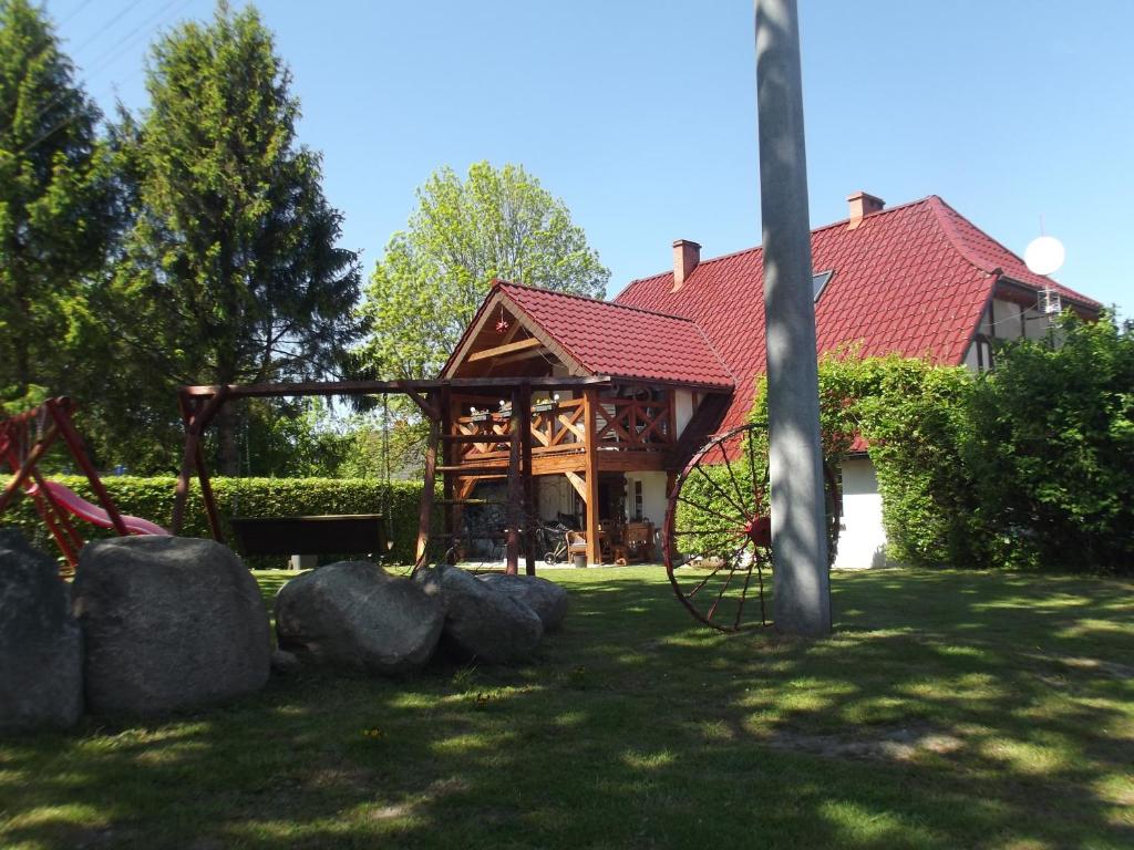杰泽扎尼Agroturystyka Bogusław X的一座有红色屋顶和一些岩石的房子