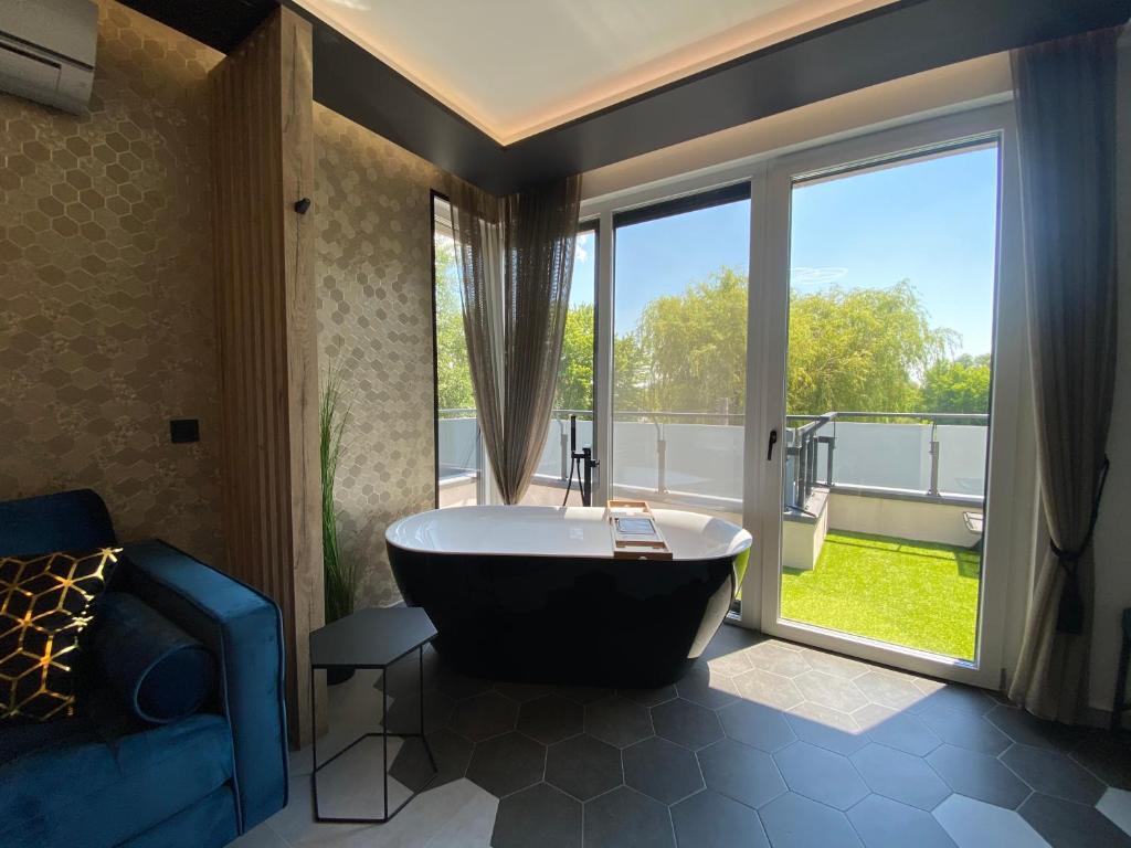 凯斯特海伊Relax Sauna Apartman privát finn szaunával的窗户前带大浴缸的浴室