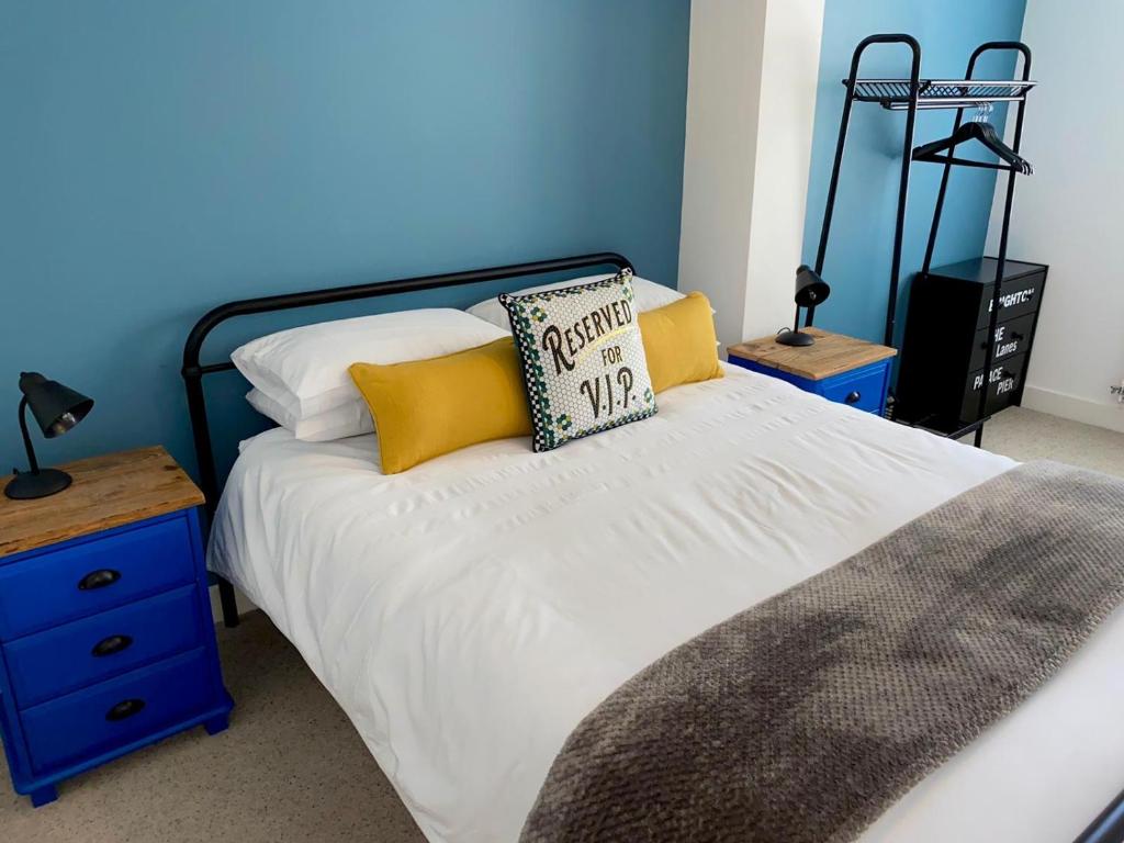 布莱顿霍夫Kemp Town Sea View Balcony Apartment的一张带黄色和白色枕头的床和蓝色的墙壁