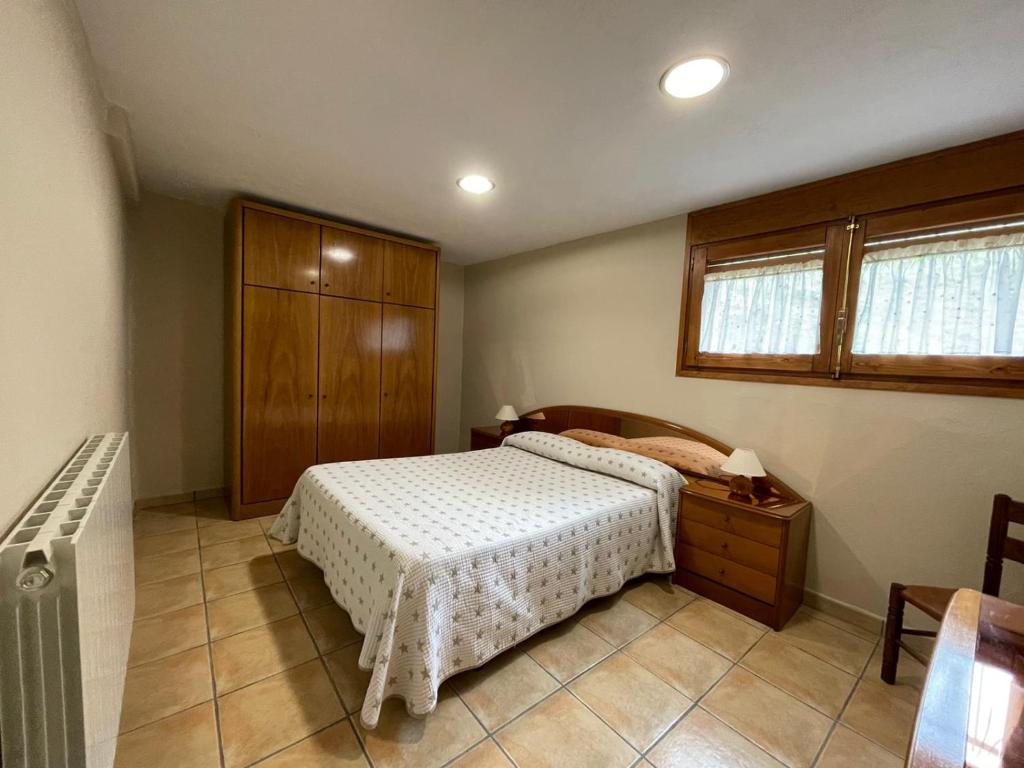 圣费柳-德帕利亚罗尔斯La Badia Nova的一间卧室配有一张床和一个木制橱柜