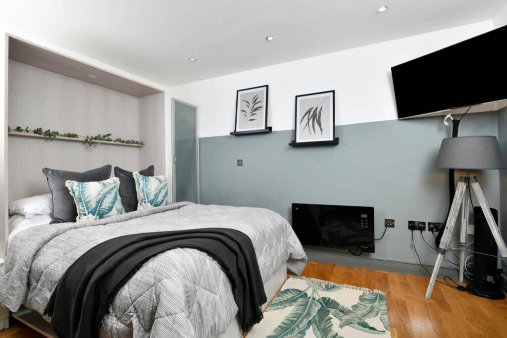 利兹Modern studio apartment in Leeds City Centre (LS1)的一间卧室配有一张床和一台平面电视