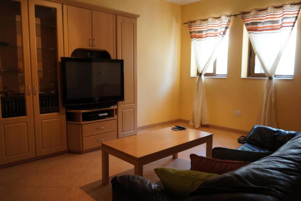 比尔基卡拉Private room in Shared apartment close to University of Malta & Mater Dei的带沙发、桌子和电视的客厅
