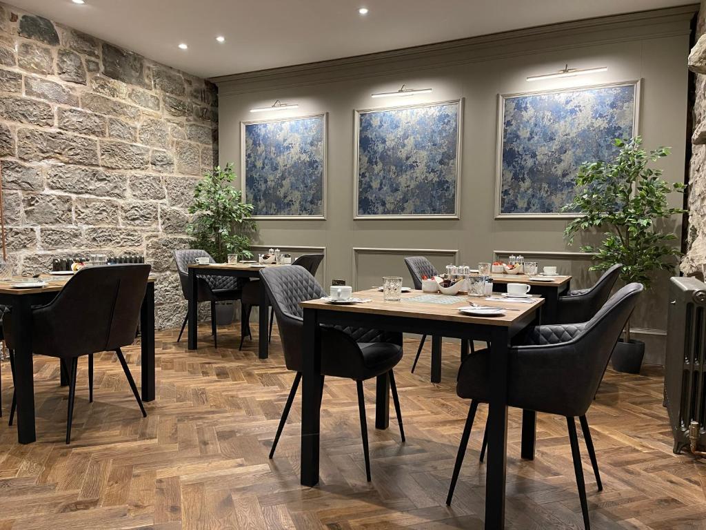 爱丁堡Ben Cruachan Guest House的用餐室设有桌椅和窗户。