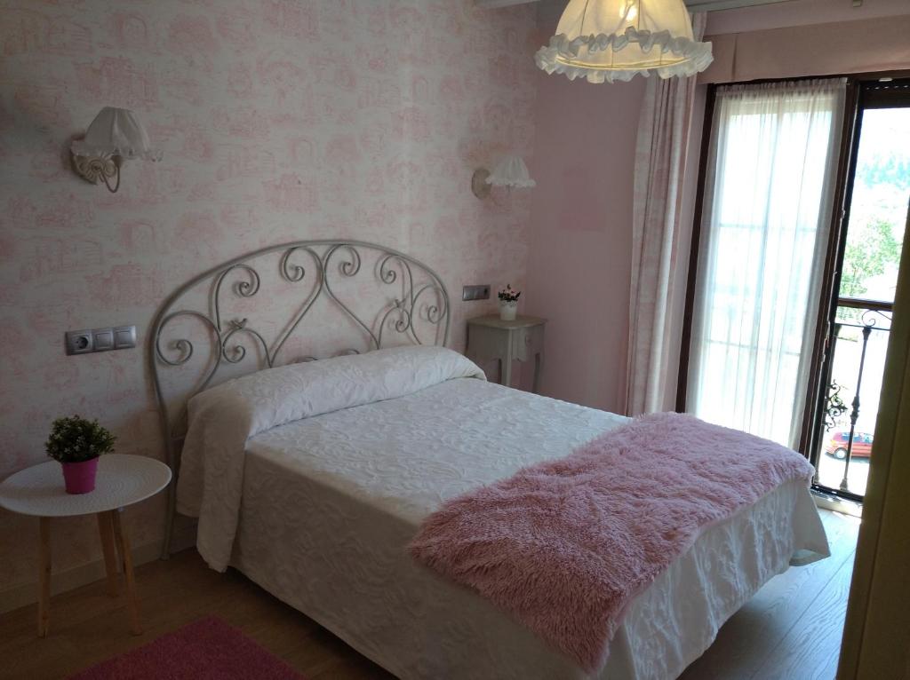 阿里纳斯·德·卡伯瑞勒斯Las Cabraliegas 2的卧室配有白色床和粉色毯子
