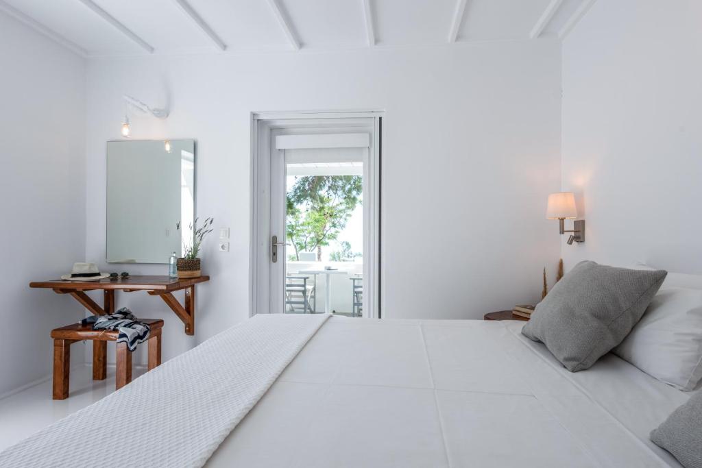 凯特利奥斯Casa Montzo boutique hotel的白色卧室配有一张大床和一张桌子