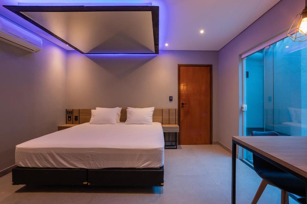 普雷图河畔圣若泽Drops Motel São José do Rio Preto的一间卧室配有一张紫色照明床