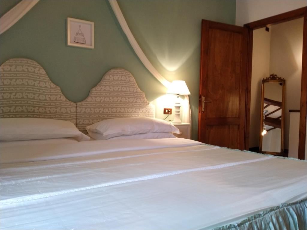皮恩扎Small lovely home in Pienza的卧室配有一张大白色的床和大床头板