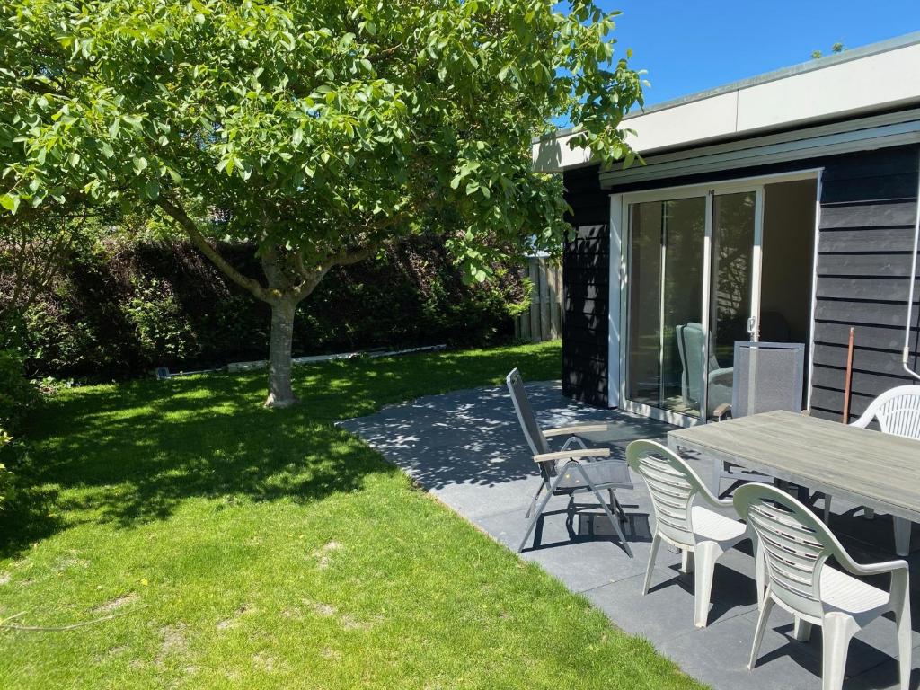 布勒伊尼瑟House in a quiet location in Zeeland 2的一个带桌椅和树的庭院