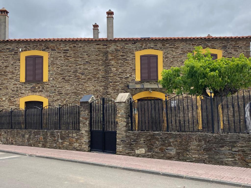 La CodoseraLa Casa Grande de Adolfo的砖砌的建筑,有栅栏和树
