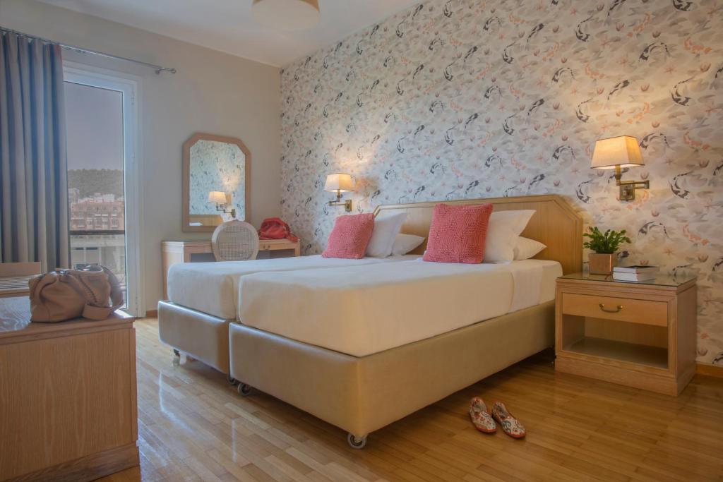 雅典德利杰家庭公寓式酒店的卧室配有带粉红色枕头的大型白色床