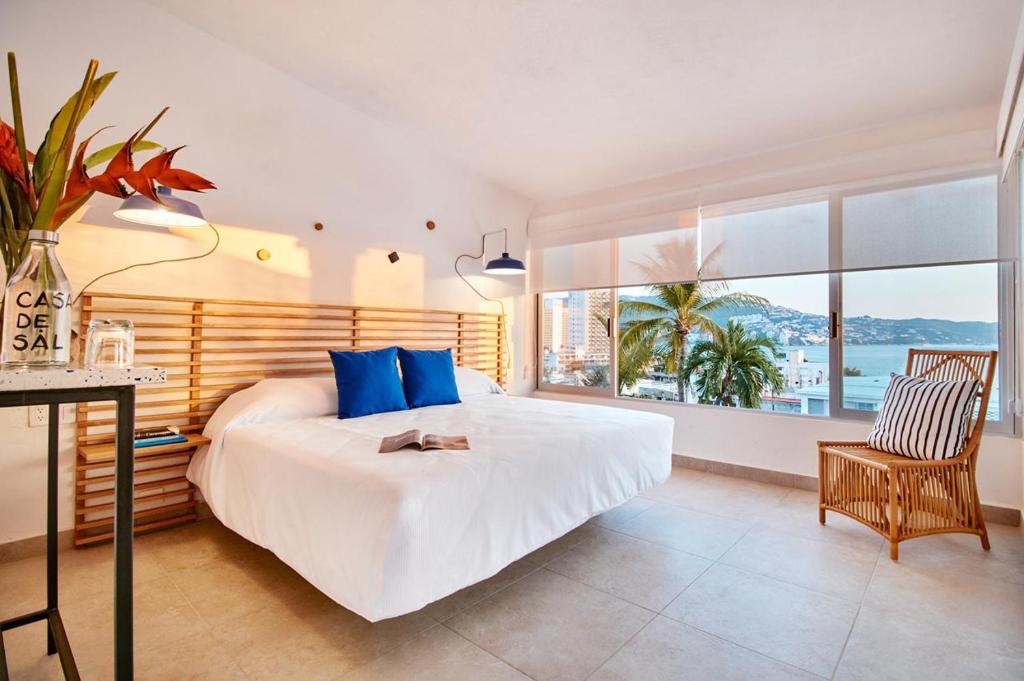 阿卡普尔科Hotel Casa de sal的一间卧室配有一张带蓝色枕头的大床